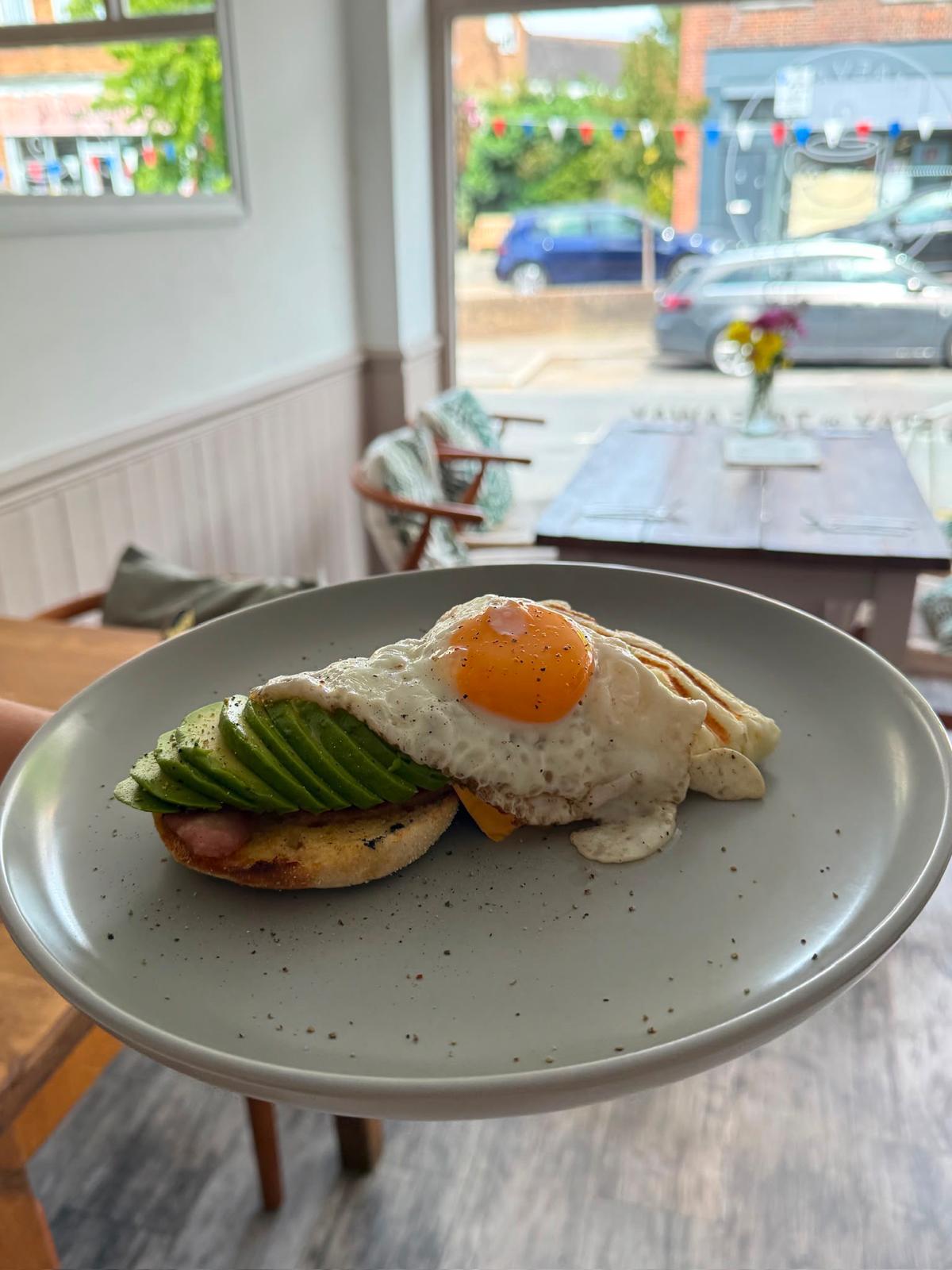 Avocado and fried egg on toasted muffin by the window