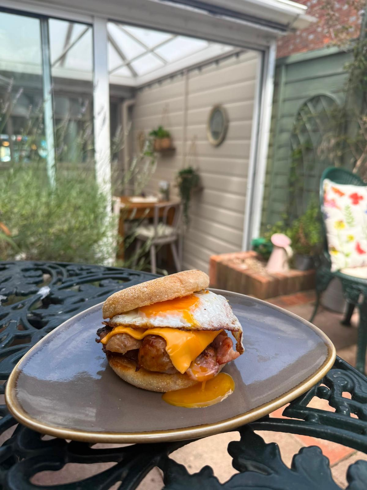Loaded breakfast muffin with sausage, bacon, cheese and egg